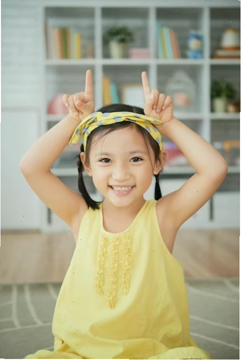 Cô bé hoạt hình người hoa tươi cười ngồi tại nhà